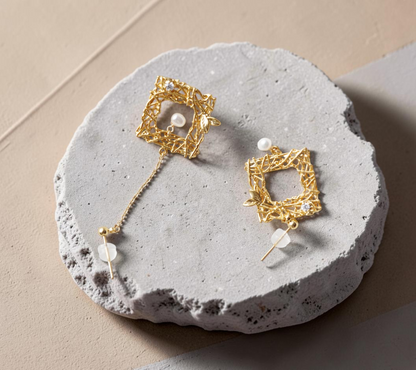 Findingyoyo Chirping Window earrings featuring gold-filled square frames with freshwater pearls on white fabric.