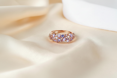 Findingyoyo Olivetta ring in 18K rose gold plated sterling silver with moissanite stones on a champagne silk fabric.