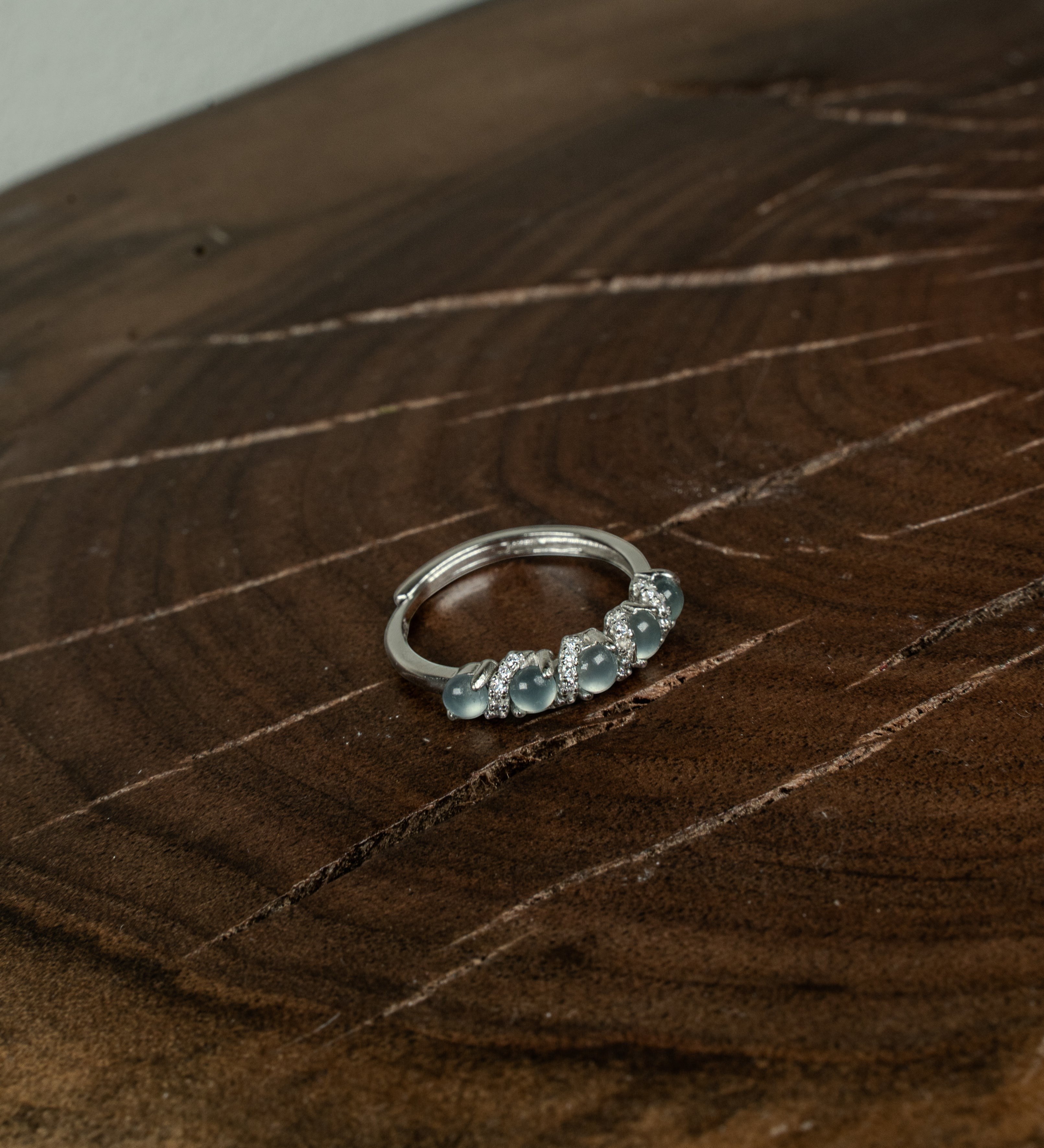 Findingyoyo adjustable ring featuring blue Guatemalan jadeite stones and zircon accents set in rhodium-plated silver.