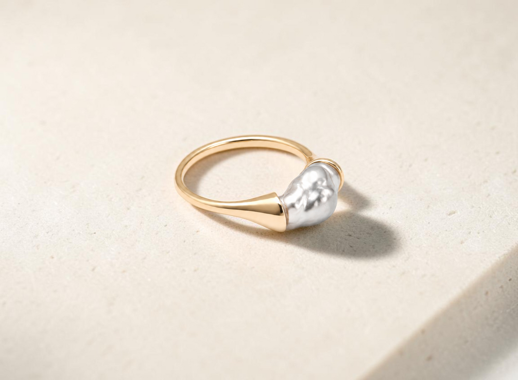 Findingyoyo Wavy Ring featuring an iridescent black Tahitian keshi pearl set on a solid 14K yellow gold band.